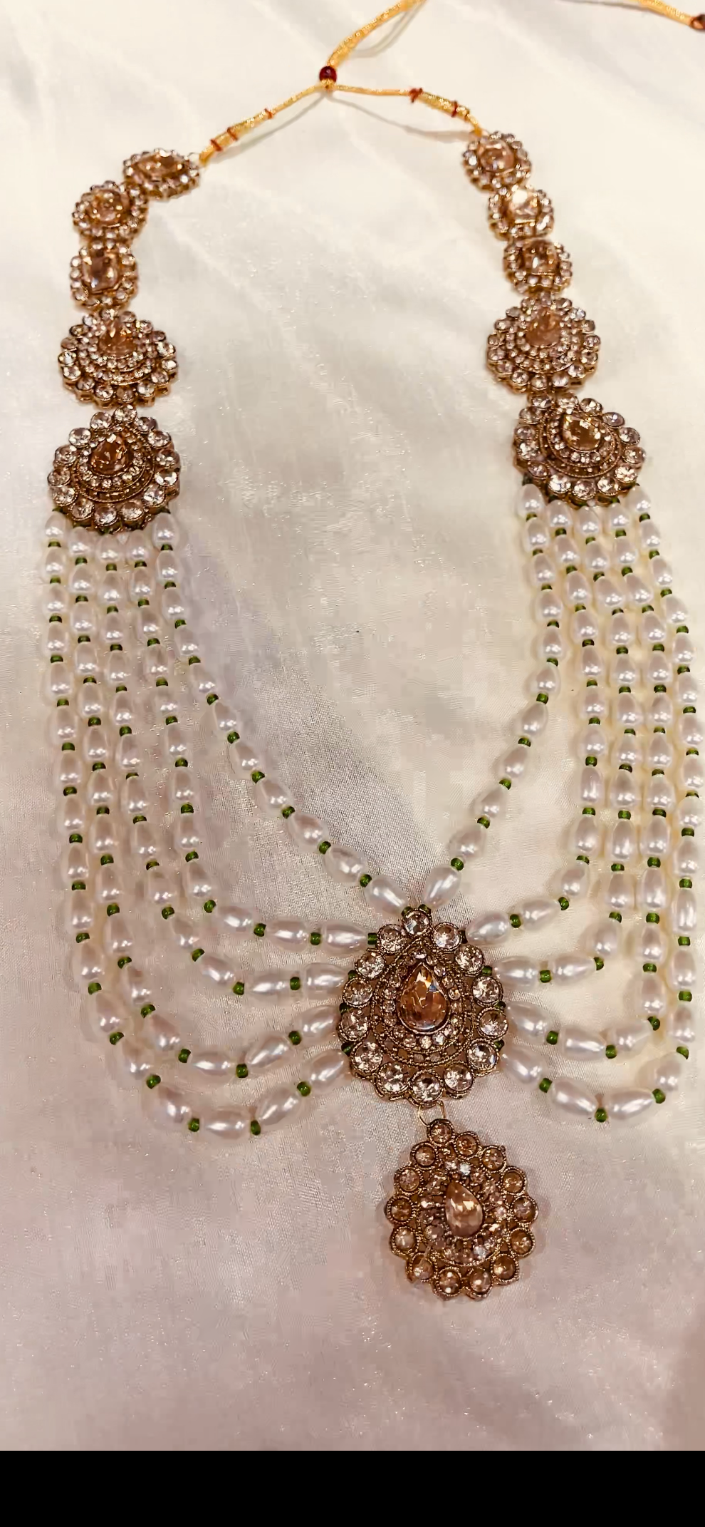 Groom’s pearl and antique gold necklace with green beadwork